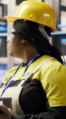 Dikey video Akıllı güneş panelleri fabrika mühendisi üretim hatlarını denetlemek için tablet kullanıyor. Sektör 4.0 fotovoltaik fabrikasındaki kadın makinelerin en uygun verimlilikte çalışmasını sağlar.