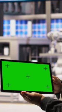 Güvenilirliği sağlamak için otomatik sistemleri test etmek için yeşil ekran tableti kullanan dikey video akıllı fabrika uzmanı. Sanayi 4.0 fabrika teknisyeni, dar boğazları tanımlamak için krom anahtar aygıtı kullanıyor ve