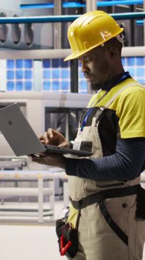 Dikey video akıllı fabrika uzmanı, otomatik sistemleri test ediyor, üretim performansını izliyor. Sanayi 4.0 fabrika teknisyeni, A kamerasının darboğazını tespit etmek ve optimize etmek için makine denetliyor.