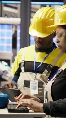 Dikey video mühendisliği ekibi akıllı fabrikada bilgisayar kullanarak robot montaj hatlarını denetliyor ve imalat sırasında kalite kontrolü sağlıyor. Takım çalışma arkadaşları otomatik taşıma bantlarını izler