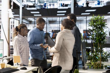Modern bir ofiste hedef verileri ve performans ölçümlerini inceleyen iş ortakları, sürdürülebilir bir girişim geliştirme için kurumsal strateji ve karar verme mekanizmasına odaklanıyor.