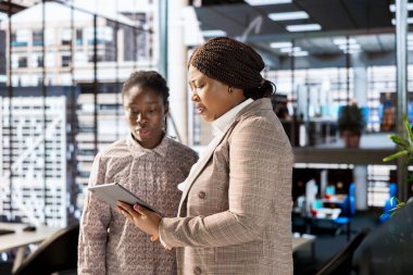 Afro-Amerikan ekibi, bir kurumsal ofisteki finansal planlama projesinde işbirliği yaparak, gelecekteki şirket büyümesi için bilgilendirilmiş kararlar almak için takım çalışması ve veri analizini vurguluyor..