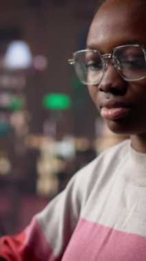 Dikey Video Afrikalı Amerikalı öğrenci kütüphanede akademik araştırma koleksiyonuna danışmanlık yapıyor, üniversite diplomasını almak için yaklaşan sınavlara çalışıyor. Kız burslu çalışıyor, eğitim görüyor. Kamera.