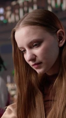 Halkla ilişkileri ve toplumsal etkisini araştıran dikey video entellektüel üniversite öğrencisi, bir sınıf ödevini tamamlamak için kütüphane arşivlerinden dizüstü bilgisayar ve eğitim materyallerinden yararlanıyor