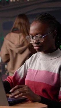 Üniversitenin kütüphanesindeki veritabanından veri toplayarak edebiyat ödevine odaklanan Dikey Video Genç Öğrencisi, daha fazla akademik bilgi toplamak için araştırma araçları kullanıyor. Kamera B.