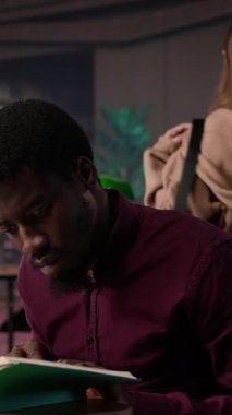 Dikey Video Afrikalı Amerikalı öğrenci diş hekimliği tezi için sahte dişleri inceliyor ve kampüs kütüphanesinde uygun aletlerle stomatoloji araştırması yapıyor. Adam kariyerine hazırlanıyor. Kamera B.