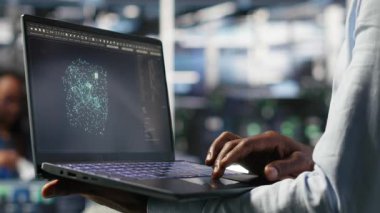 Yapay zeka veri analizi grafiklerini yorumlamak için dizüstü bilgisayar kullanarak veri merkezini kapat. Sunucu odası teknisyeni not defterinde yapay zeka kullanıyor sistem ölçümleri, kamera B