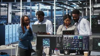 Sunucu tesisinde çalışan gülümseyen veri merkezi uzmanlarının portresi, verileri analiz etmek için düğüm ağacı yazılımı kullanıyor. Mutlu takım vites performansını arttırmak için görsel programlama kullanıyor, kamera A