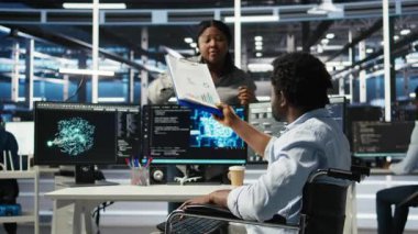 Belden aşağısı felçli bir sunucu merkezi yöneticisiyim. İş arkadaşından yapay zeka ağaç yazılımı kullanarak evrak alıyorum. Veri merkezinde engelli bir adam iş arkadaşından belge alıyor, kamera A 'dan.