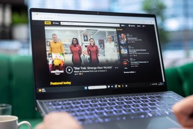 Bükreş, Romanya - 30 Temmuz 2024 - IMDb web sitesinde metascore ve derecelendirme arayan sinemacı eleştirileri okuduktan sonra film seyrediyor. Pervane alçıyı kontrol ediyor.