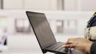 Sürdürülebilir sanayi fabrikasındaki teknisyen dizüstü bilgisayar kullanarak üretim ekipmanlarını izliyor ve arızaları teşhis ediyor. Fabrika işçisi koordinatları güneş modülü montaj hattı üzerinde onarım görevleri, kamera B kapatın