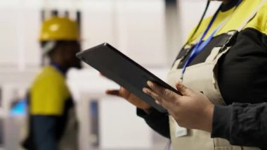 Akıllı fabrikadaki mühendis, imalat sırasında kalite kontrolü sağlayan tablet uygulamasını kullanarak robot montaj hatlarını denetliyor. İşçi otomatik taşıma sistemlerini cihaz kullanarak izliyor, kamera B, kapat