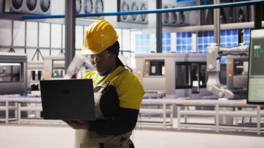 Gülümseyen güneş panelleri fabrika mühendisinin portresi dizüstü bilgisayardaki verileri analiz ederek vites arızalarını öngörüyor. Mutlu fotovoltaik tesis çalışanları defter kullanıyor, bakım prosedürlerini takip ediyor, kamera A