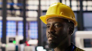 Yenilenebilir enerji üreten sanayi 4.0 fabrikasındaki profesyonel test ekipmanlarını kapatın. Fotovoltaik 'teki Afrikalı Amerikalı adam. Akıllı fabrika, rutin teftiş, kamera B