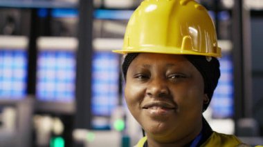 Sistem performans ölçümlerine bakan akıllı fotovoltaik fabrikasındaki mutlu mühendis. Güneş panellerindeki gülümseyen işçiler IoT sensörleri aracılığıyla enerji üretimini takip ediyorlar.