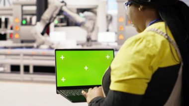 Sistem performans ölçümlerine bakmak için krom anahtar dizüstü bilgisayar kullanan fotovoltaik fabrikasında mühendis. Enerji üretimini izlemek için yeşil ekran maketi kullanan 4.0 fabrika işçisi, kamera B