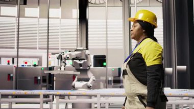 Akıllı fabrika mühendisi robot montaj hatlarını denetliyor, imalat sürecinde kalite kontrolü sağlıyor. İşçi otomatik taşıma sistemlerini izliyor, bakım yapıyor, kamera A