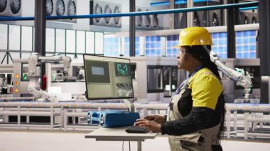 PC 'de yazan neşeli fabrika mühendisinin portresi, üretim hatlarının izlenmesini denetliyor. Endüstrideki neşeli kadın 4.0 fabrika teçhizatı en uygun verimlilikte çalışıyor, kamera A