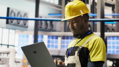 Akıllı fabrikadaki mühendis dizüstü bilgisayar yazılımı kullanarak IoT sensör verilerini analiz ediyor. Fotovoltaik sistemlerin işlevsel güvenilirliğini yöneten sanayi 4.0 fabrika işçisi not defteri, kamera B