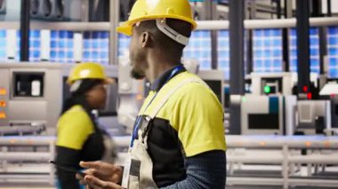 Endüstriyel fabrikadaki teknisyen, ekipman hatalarını tespit etmek için tablet uygulaması kullanıyor. Montaj hatlarındaki tamir görevlerini koordine etmek için dijital aygıt kullanan fabrika uzmanı, kamera A