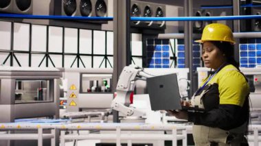 Akıllı fabrikada yürüyen mühendis, IoT sensör verilerini analiz etmek ve vites verimliliğini artırmak için dizüstü bilgisayar kullanıyor. Endüstri 4.0 bitkisel uzmanlık sistemi tanılama işlemleri durdurma süresini azaltmak için kamera A