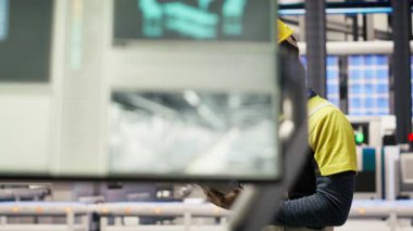 Mühendis, güneş paneli üretim hattı ekipmanlarını tablet uygulaması kullanarak denetliyor. İşçi, dijital cihaz uygulaması kullanarak otomatik sanayi 4.0 fabrikasında fotovoltaik montaj sistemleri sürdürüyor, kamera B