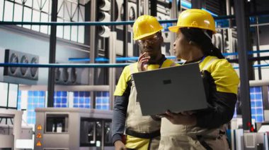 Mühendislik ekibi birlikte çalışıyor, güneş paneli üretim hattı ekipmanlarını denetliyor. Otomatik endüstri 4.0 fabrikasındaki fotovoltaik montaj sistemlerini koruyan takım arkadaşları, kamera A