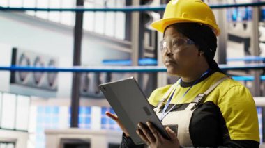 Akıllı fabrika mühendisi IoT sensör verilerini analiz etmek için tablet kullanıyor, ekipman işletim verimliliğini artırıyor. Endüstriyel fabrika işçisi üretim kesintilerini azaltmak için sistem kontrolü yapıyor, kamera B