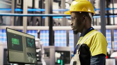 Bilgisayar klavyesinde yazan akıllı bir fabrika çalışanı otomatik sistemleri test ediyor, bakım yapıyor. Endüstri 4.0 tesis çalışanı, ekipman ve tamir hatalarını incelemek için bilgisayar kullanıyor, kamera B