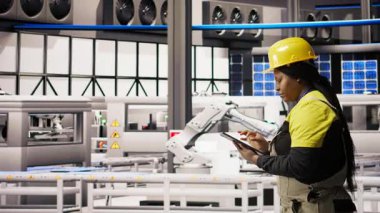 Güneş enerjisi kurulum sürecini denetleyen teknisyenler, otomatik makinelerin sorun çıkarması, yenilenebilir enerji üretim tesisinde robotik kolların kalibre edilmesi, kamera A