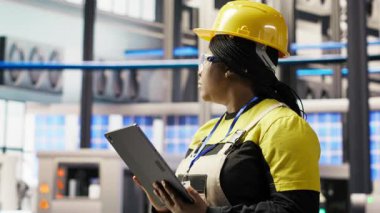 Akıllı güneş panelleri fabrika mühendisi üretim hatlarını denetlemek için tablet kullanıyor. Sektör 4.0 fotovoltaik fabrikasındaki kadın makinelerin en uygun verimlilikte çalışmasını sağlar.