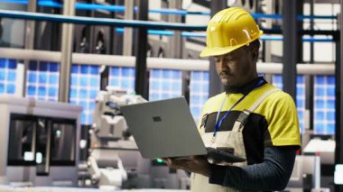 Akıllı fabrika uzmanı, otomatik sistemleri test ediyor, üretim performansını izliyor. Endüstri 4.0 fabrika teknisyeni, B kamerasını tespit etmek ve optimize etmek için makine denetliyor.