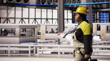 Tamirci alet çantasını tutuyor, akıllı fabrikada yürüyor, bakım yapmaya hazırlanıyor. Tamirci sektör 4.0 tesisini teftiş ediyor, tamir için ekipman hasarı arıyor, bakım yapıyor, kamera A