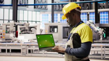 Akıllı fabrikadaki mühendis IoT sensör verilerini analiz etmek için yeşil ekran dizüstü bilgisayar kullanıyor. Endüstri 4.0 bitkisel uzmanlık sistemi tanımlaması krom anahtar model dizüstü bilgisayar, kamera A