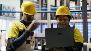 Mühendislik ekibi fotovoltaik fabrikasında birlikte çalışarak sistem performans ölçümlerine bakıyor. Sektör 4.0 'daki ekip çalışması IoT sensörleri ve kamera B aracılığıyla enerji üretimini takip ediyor.