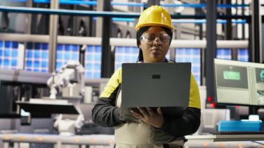 Bilgisayar kullanarak öngörü onarımı yapan mühendis, IoT sensör verilerini analiz ediyor, akıllı fabrika ortamında fotovoltaik sistemlerin işlevsel güvenilirliğini yönetiyor, kamera B