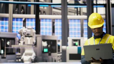 Akıllı fabrikadaki mühendis yenilenebilir enerji çözümleri uyguluyor güneş teknolojisini otomatik montaj sistemleriyle birleştirerek, üretim verimliliğini artırarak, kamera B