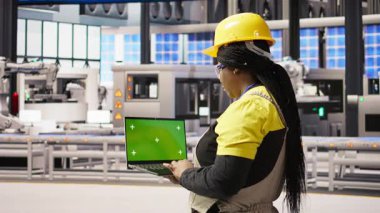 Sistem performans ölçümlerine bakmak için krom anahtar dizüstü bilgisayar kullanan fotovoltaik fabrikasında mühendis. Enerji üretimini izlemek için yeşil ekran maketi kullanan 4.0 fabrika işçisi, kamera A