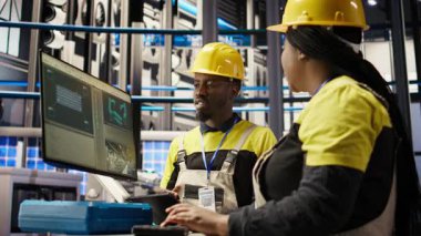 Endüstriyel fabrikadaki yönetici denetleme teknisyeni arızaları teşhis etmek için bilgisayar yazılımı kullanıyor. Fabrika ekip lideri, montaj hatlarındaki tamir görevlerini koordine etmek için iş arkadaşıyla birlikte çalışıyor. Kamera A