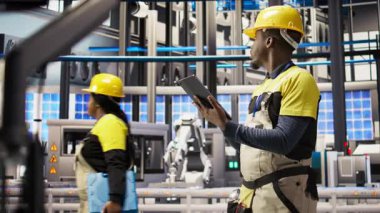 Endüstriyel fabrika teknisyeni yeşil enerji çözümleri uygulamak için tablet kullanarak güneş enerjisini montaj sistemlerine entegre ediyor. Akıllı fabrika işçisi üretim verimliliğini arttırmak için cihaz, kamera A 'yı kullanıyor.