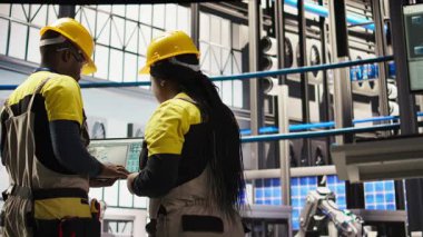 Mühendislik ekibi, yenilenebilir enerji üreten sanayi 4.0 fabrikasında rutin teftişler yapmak için birlikte çalışıyor. Fotovoltaik, akıllı fabrika, takım çalışması ekipman, kamera A