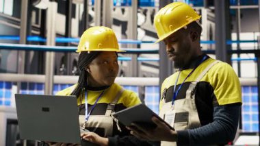 Akıllı fabrika teknisyenlerinden oluşan bir ekip sistemleri test etmek ve bakım yapmak için birlikte çalışıyor. Endüstri 4.0 fabrika tamircileri teknik arızaları tespit etmek için ekipmanları denetliyor, beyin fırtınası yapıyor, kamera B