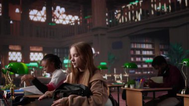 Üniversite öğrencisi üniversite kütüphanesindeki sınavlara çalışmak için kitap ödünç alıyor, okul ödevi için araştırma yapıyor. Motivasyonu olan genç bir kız kendini öğreniyor. Kamera B.