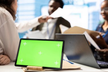 Pazarlama ekibi tabletteki yeşil ekranın yanındaki performans ölçümlerini inceleyerek, büyük veri içgörülerini ve detaylı analizleri stratejileri iyileştirmek ve proje etkinliğini artırmak için koz olarak kullanıyor.