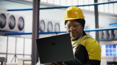 Kadın, 4.0 güneş paneli fabrikasında dizüstü bilgisayar kullanarak rutin kontroller yapıyor. Fotovoltaik mühendisliği akıllı fabrika test ekipmanları ve sistem ölçümleri defter kullanarak gözden geçirme