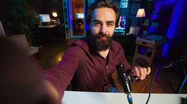 Happy influencer rgb lights stüdyosunda online şov sunuyor, selfie kamera kullanarak video bloğu çekiyor. Canlı yayın sırasında konuşan neşeli medya yıldızının POV 'u cep telefonuyla filme alındı