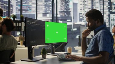 Programcı, makine öğrenme modellerini eğitmek için yeşil ekran bilgisayar kullanıyor, görüntüyü yakınlaştırıyor. IT uzmanı tarafından kullanılan modelleme bilgisayarının kapatılması ve şirket sistemlerinin korunması, kamera B