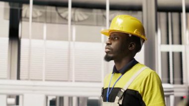 Fabrikada yürüyen, güneş paneli üretim ekipmanlarını denetleyen bir teknisyen. Otomatik endüstriyel tesiste fotovoltaik montaj sistemlerini koruyan mühendislik uzmanı, kamera B