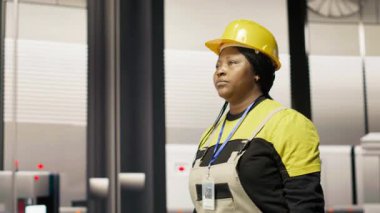 Akıllı fabrika mühendisi robot montaj hatlarını denetliyor, imalat sürecinde kalite kontrolü sağlıyor. İşçi otomatik taşıma sistemlerini izliyor, bakım yapıyor, kamera B