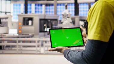 Güneş panelleri bitki teknisyeni sistemleri denetlemek için yeşil ekran tableti kullanıyor. Fotovoltaik fabrikası çalışanı, işlemleri sürdürmek için krom anahtar aygıtı üzerinde yazılım kullanır. Kamera A: